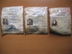 Identification cards of a woman and her two children found in a mass grave in northern Iraq.