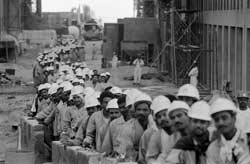 Foreign workers stand in line for the bus that takes them home after a day at work in Dubai. � 2006 Abbas