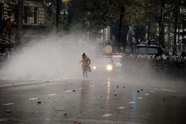 A girl flees after riot police attack protestors with tear gas and rubber bullets in downtown Tbilisi on November 7, 2007.

