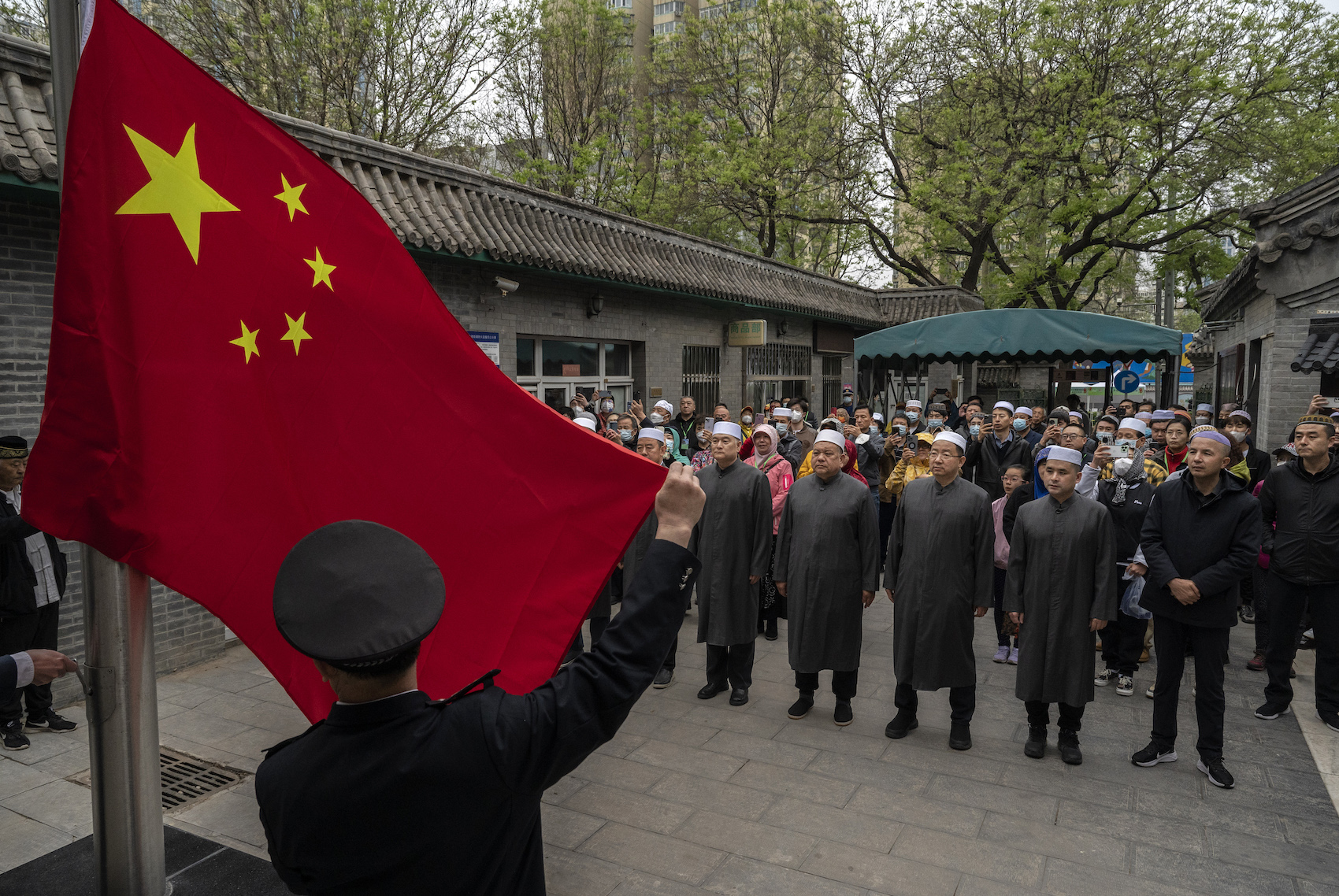 Muslimische Gläubige in China versammeln sich vor dem Hissen der Nationalflagge vor dem Eid al-Fitr-Gebet in der historischen Niujie-Moschee am 22. April 2023 in Peking, China.
