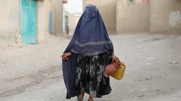 An Afghan woman carries empty containers to fetch water in Nahr-e-Shahi district in Balkh province, Afghanistan, August 6, 2023. 