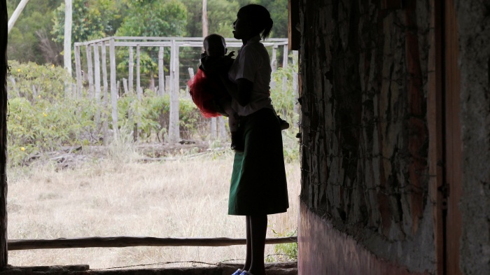 A 19-year-old woman carries her child outside her secondary school classroom in Nyeri, Kenya, January 8, 2021.