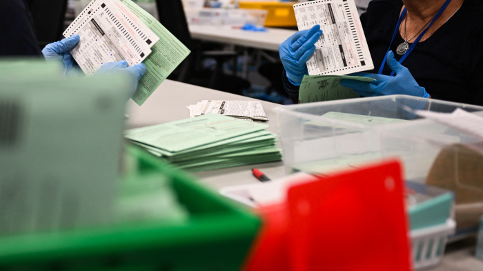 US election workers open and inspect mail-in ballot envelopes during processing inside the Maricopa County Tabulation and Election Center (MCTEC) on Election Day, November 5, 2024, in Phoenix, Arizona.