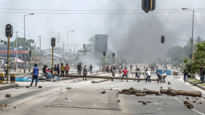 Protesters use different materials to build barricades and block a road as clashes erupt in Dar es Salaam during Tanzania's presidential elections on October 29, 2025.