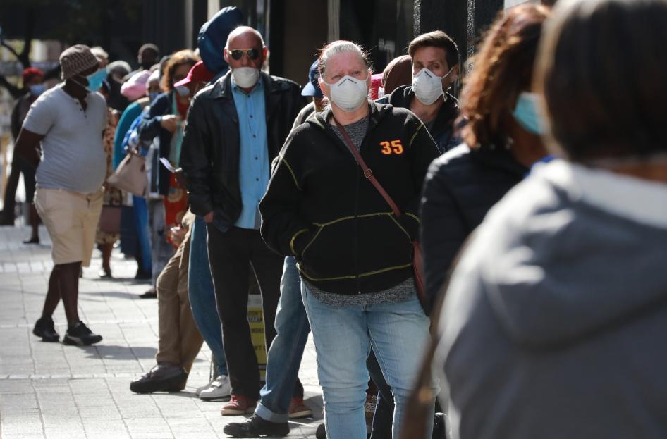 Des personnes faisaient la queue devant un bureau de l'Agence sud-africaine de sécurité sociale le 12 mai 2020 au Cap, en Afrique du Sud, afin de recevoir des prestations dans le cadre de la pandémie de Covid-19.