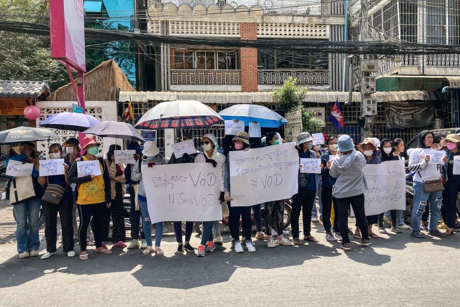 Supporters of online media outlet Voice of Democracy (VOD) hold placards in front of VOD office in Phnom Penh on February 13, 2023.