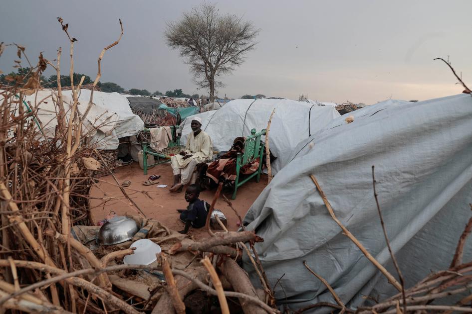 Ismail Mohamed Issa, un homme soudanais de 65 ans ayant fui le conflit dans la région du Darfour, au Soudan, photographié avec un jeune garçon devant sa tente dans un camp de réfugiés mis en place dans la ville frontalière d’Adré, au Tchad, le 29 juillet 2023. 