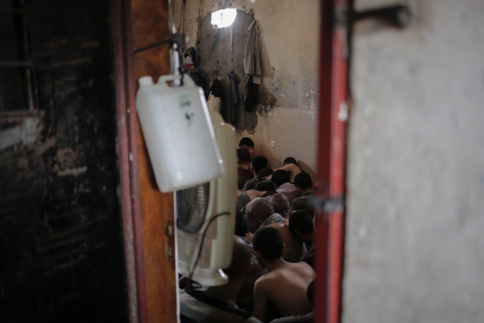 أشخاص مشتبه في انتمائهم إلى تنظيم "الدولة الإسلامية" يجلسون داخل غرفة صغيرة في سجن إلى الجنوب من الموصل، العراق، 18 يوليو/تموز 2017. 