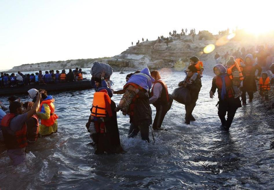 Des familles de réfugiés et de migrants au large de la côte ouest de la Turquie, non loin du village de Cesme, avancent vers des canots pneumatiques le 4 novembre 2015, afin de rejoindre l'île grecque de Chios dans la mer Egée.