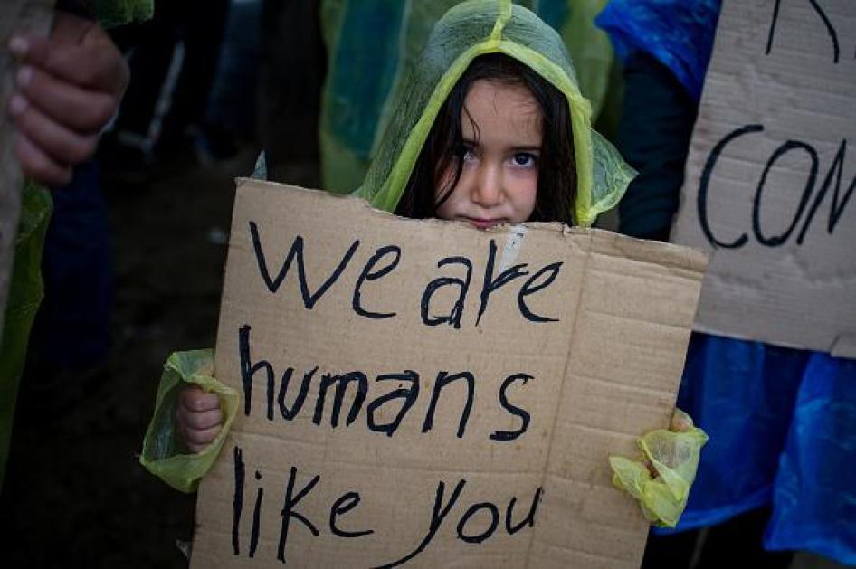 Seorang gadis memegang poster dari potongan kardus selama protes yang diadakan oleh para migran dan pengungsi untuk meminta pembukaan kembali perbatasan di sebuah kamp sementara di perbatasan Yunani-Makedonia dekat Desa Idomeni pada 23 Maret 2016. 