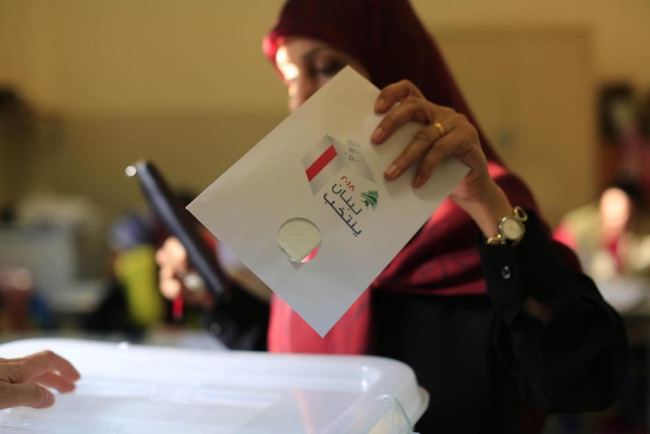 An election official shows a ballot with colors of political parties participating in the parliamentary election shortly after the polling stations closed in Beirut, Lebanon on May 6, 2018. © 2018 Bilal Hussein/AP Photo