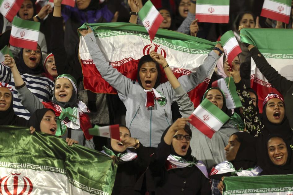 هواداران زن ایرانی در حال تشویق با تکان دادن پرچم کشور در جریان مسابقه دوستانه بین ایران و بولیوی در ورزشگاه آزادی در تهران، سه‌شنبه، ۱۶ اکتبر ۲۰۱۸.