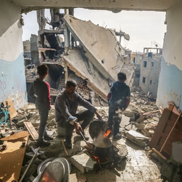 A man cooks inside his damaged apartment in the Khezaa district in Khan Yunis, Gaza, November 25, 2023. 