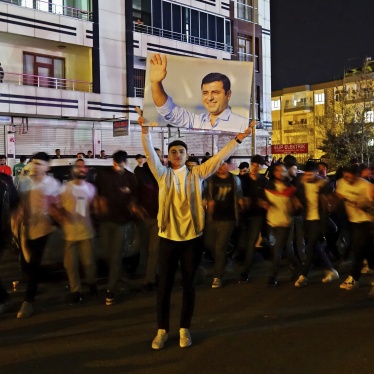 A young man holds up a photo of Kurdish politician Selahattin Demirtaş, in prison since November 4, 2016, at a demonstration in Diyarbakir, Türkiye, April 4, 2024. 