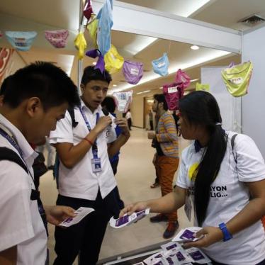 Students receive free condoms at an event organized by the United Nations Population Fund in Mandaluyong, Metro Manila, July 11, 2014.