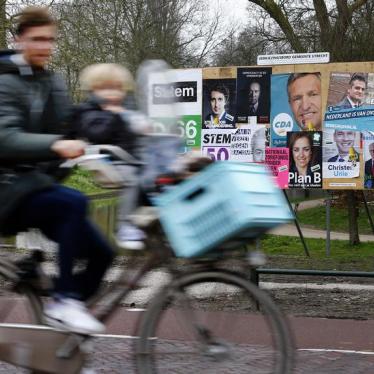 A man and child cycle past an election poster billboard the day before a general election, in Utrecht, Netherlands, March 14, 2017.
