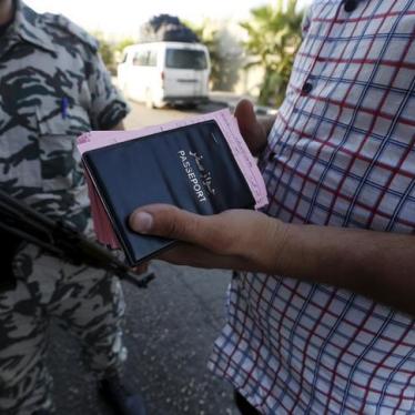A General Security officer stands by as a Syrian bus driver carries the passports and departure cards of Syrians arriving in Lebanon. 