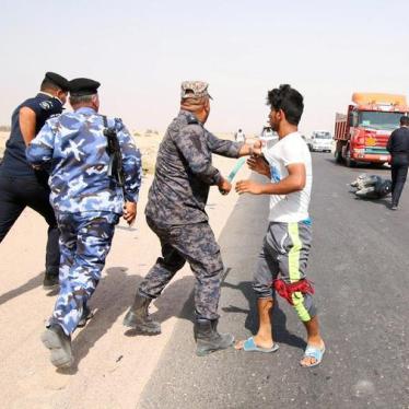 An Iraqi security officer grabs a protester during a demonstration at al-Burjisiya oil field near Basra City, Iraq, July 17, 2018. © 2018 Essam al-Sudani/Reuters