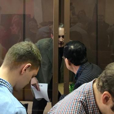 Dennis Christensen (behind the windows) talks with his interpreter at the Zheleznodorzhy District Court in Oryol, January 28, 2019
