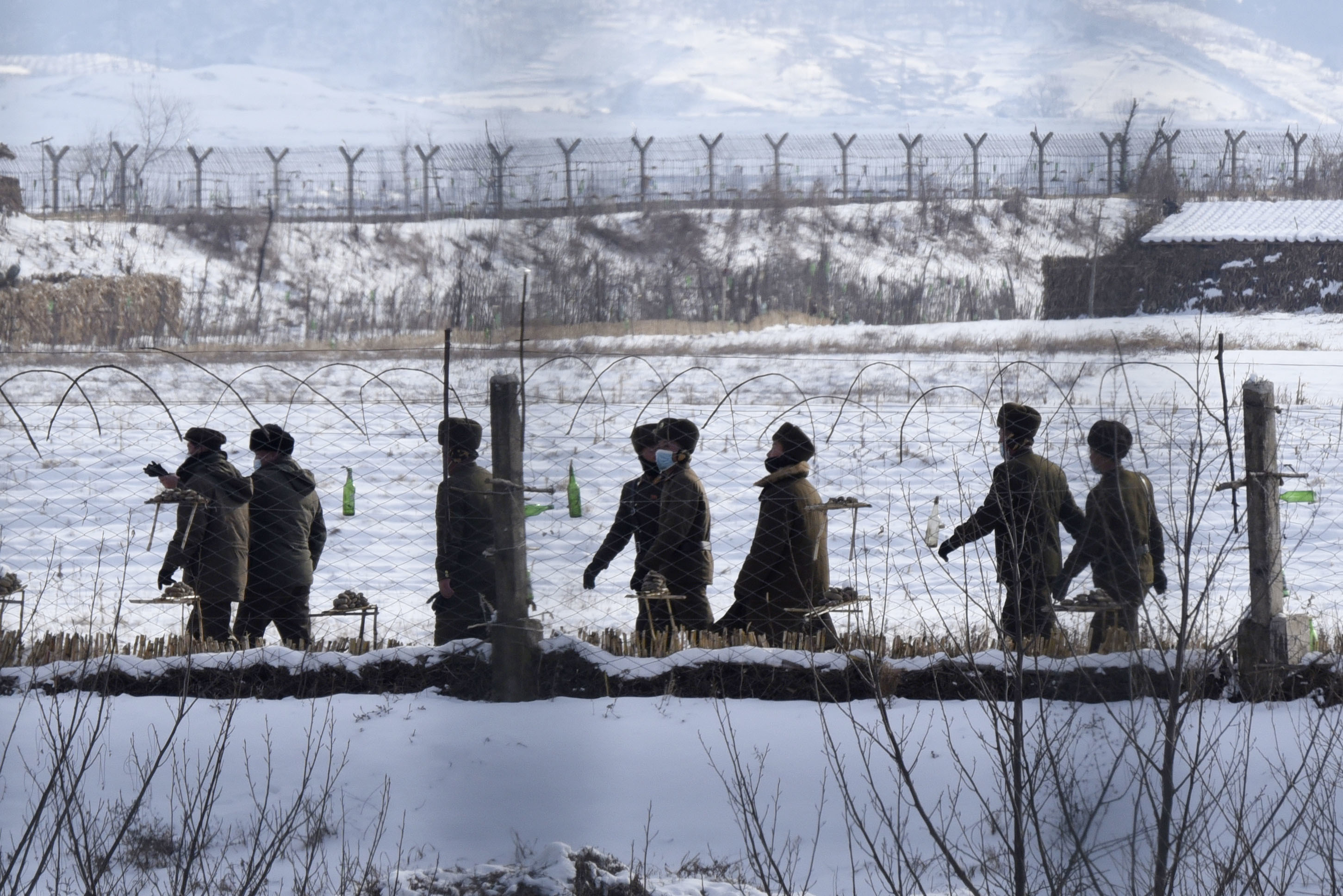Des soldats nord-coréens patrouillaient dans une zone clôturée au bord d’une rivière dans le comté d’Uiju (province de Pyongan du Nord), près de la frontière avec la Chine, le 22 décembre 2022. 