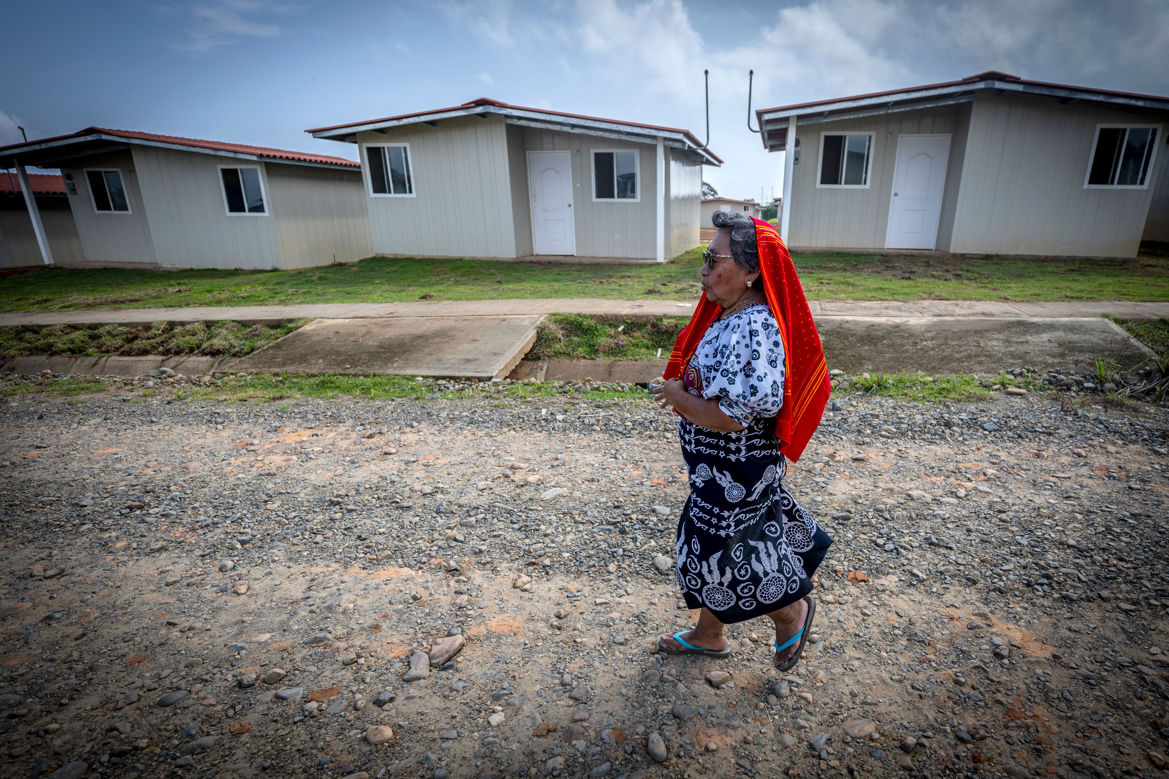 Une femme appartenant à la communauté autochtone Guna ayant dû quitter l’île de Gardi Sugdub, tout comme d’autres membres de sa communauté, marchait devant des maisons  à Isber Yala (comarque de Guna Yala), au Panama, le 30 août 2023. 