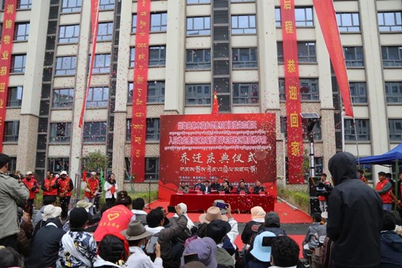 Crowd attending a ceremony in front of a new apartment buildings