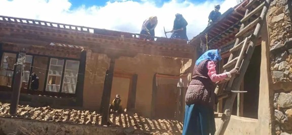 Villagers demolish their former houses