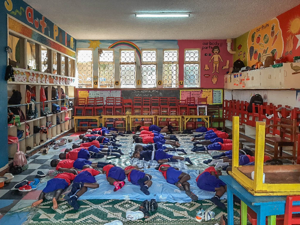 Children asleep on the floor of a classroom