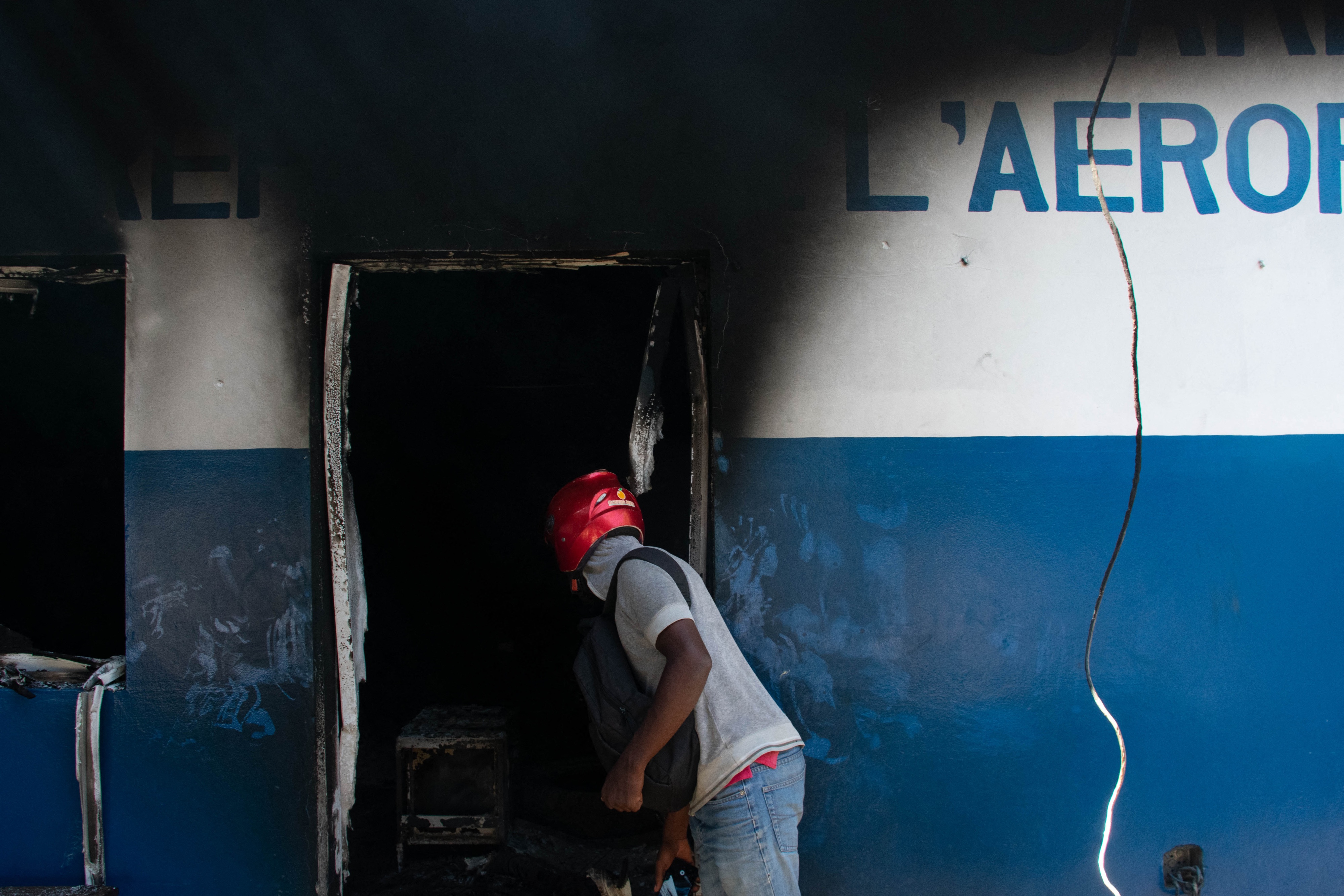 Un homme regarde à l’intérieur des locaux incendiés du Commissariat de l'Aéroport à Port-au-Prince (Haïti), le 5 mars 2024