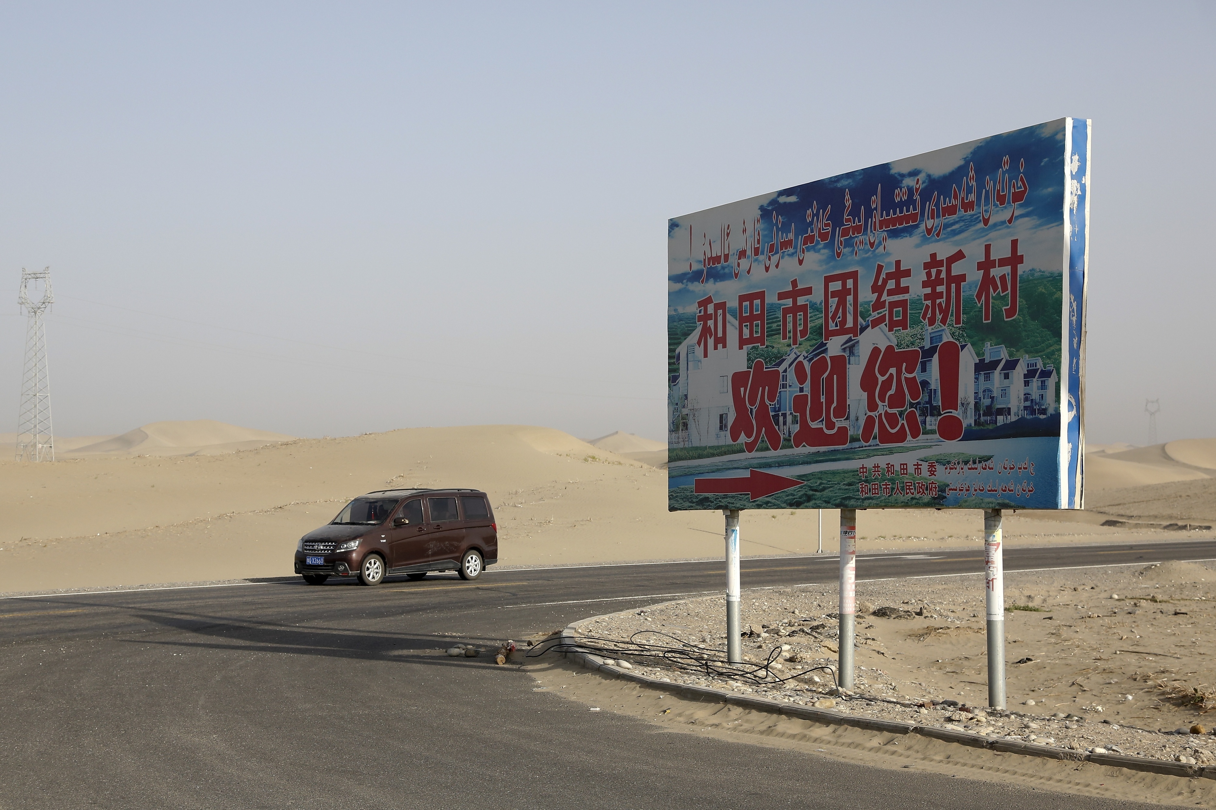 Un panneau avec le message « Bienvenue au Nouveau Village de l'Unité de Hotan ! », photographié le 21 septembre 2018 dans la préfecture de Hotan, située dans la région du Xinjiang en Chine. 