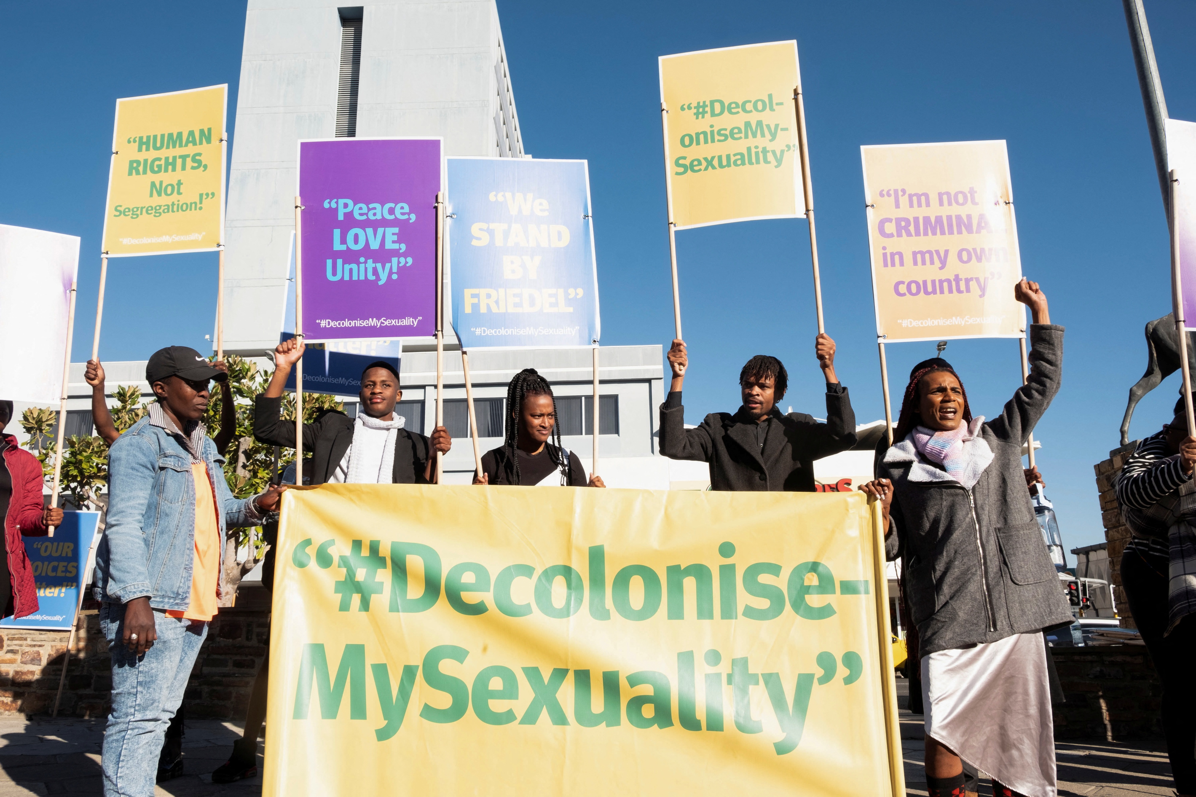 People hold banners in support of LGBTQ rights outside the high court which made a landmark ruling in favor of LGBTQ communities in Windhoek, Namibia, June 21, 2024.