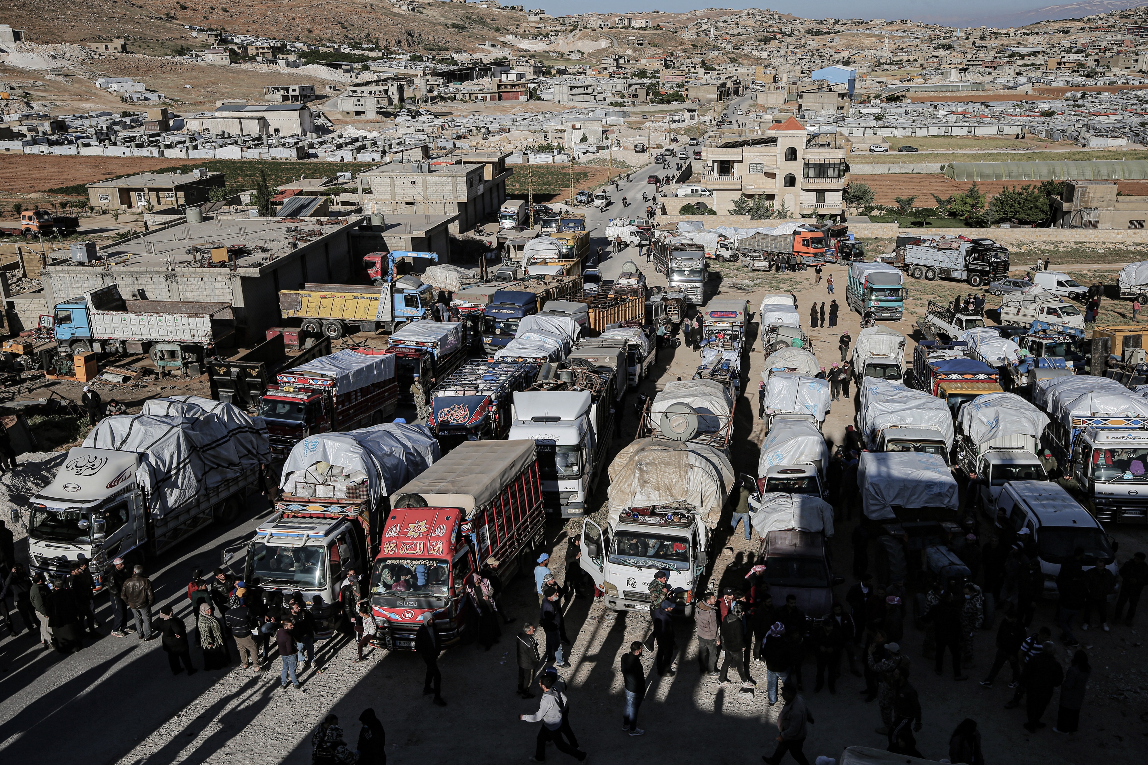Des camions et des voitures de réfugiés syriens se préparent à quitter le Liban pour retourner en Syrie, le 14 mai 2024.