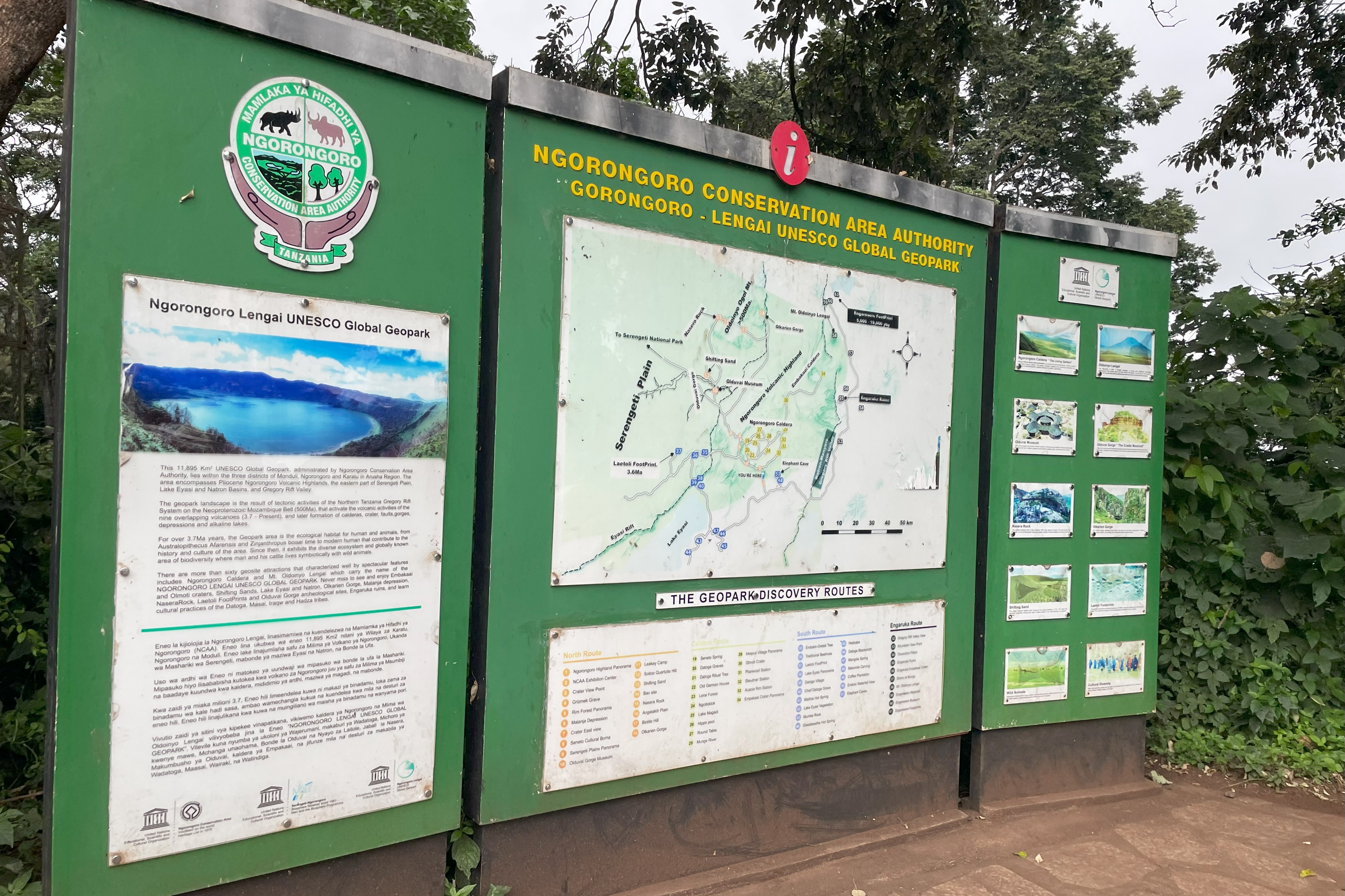 A large green sign with a map and tourist information for the Ngorongoro Conservation Area