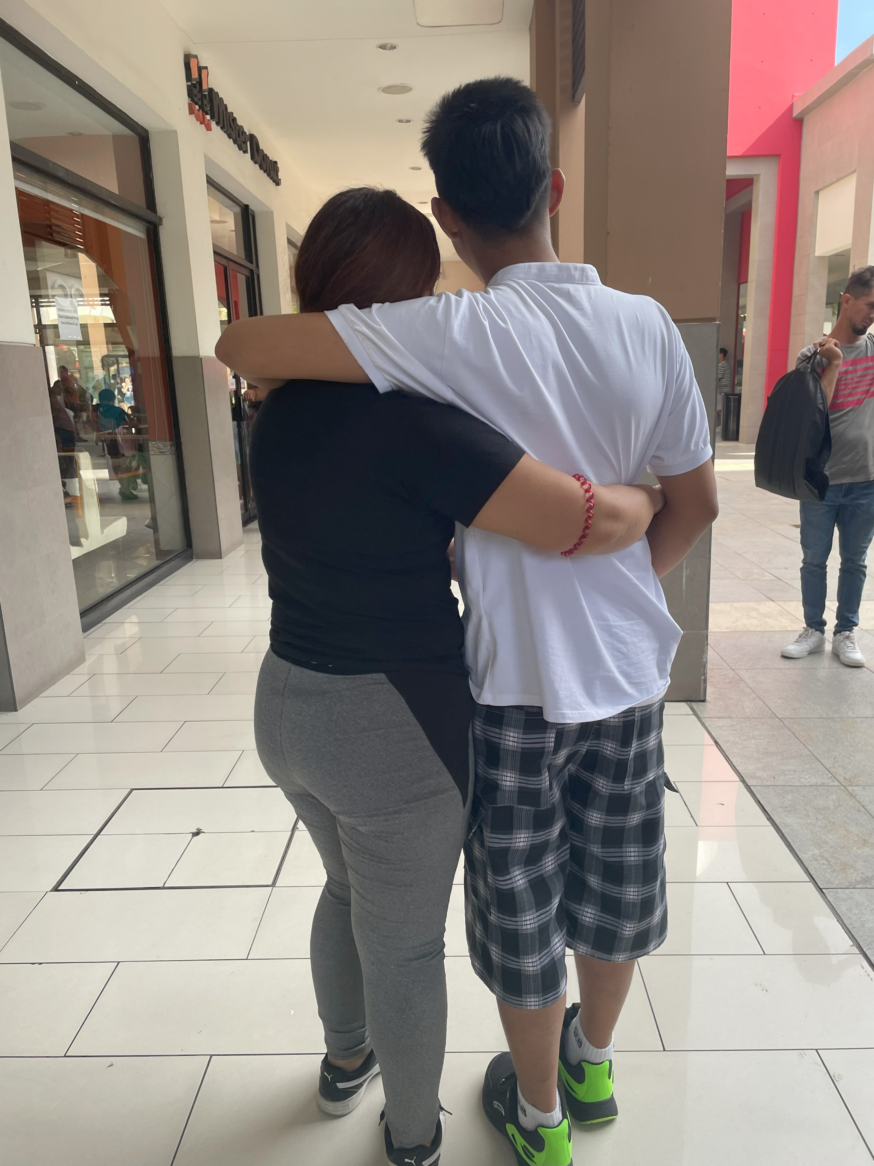 A teen boy hugs his mother