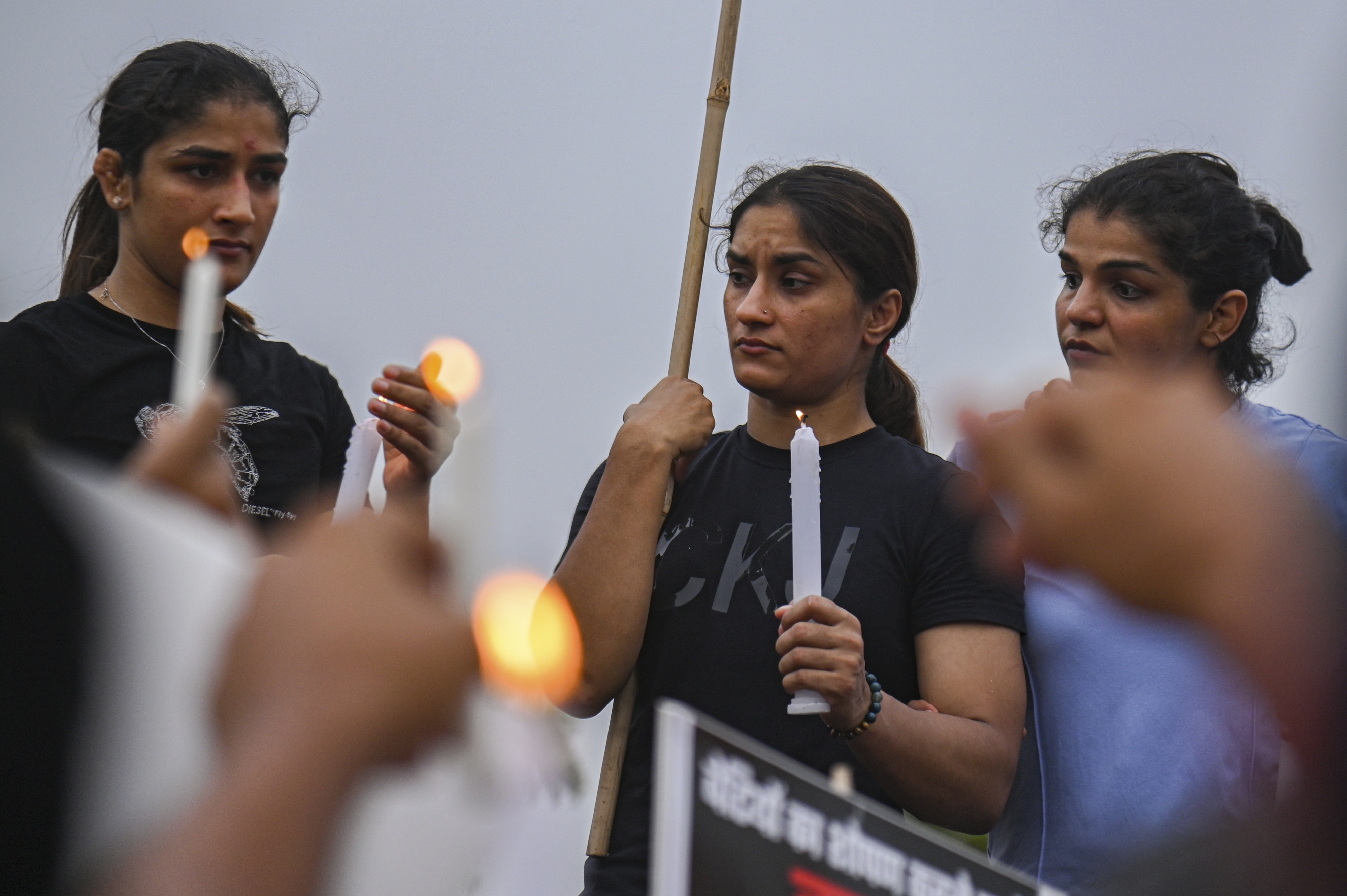 3 women holding candles