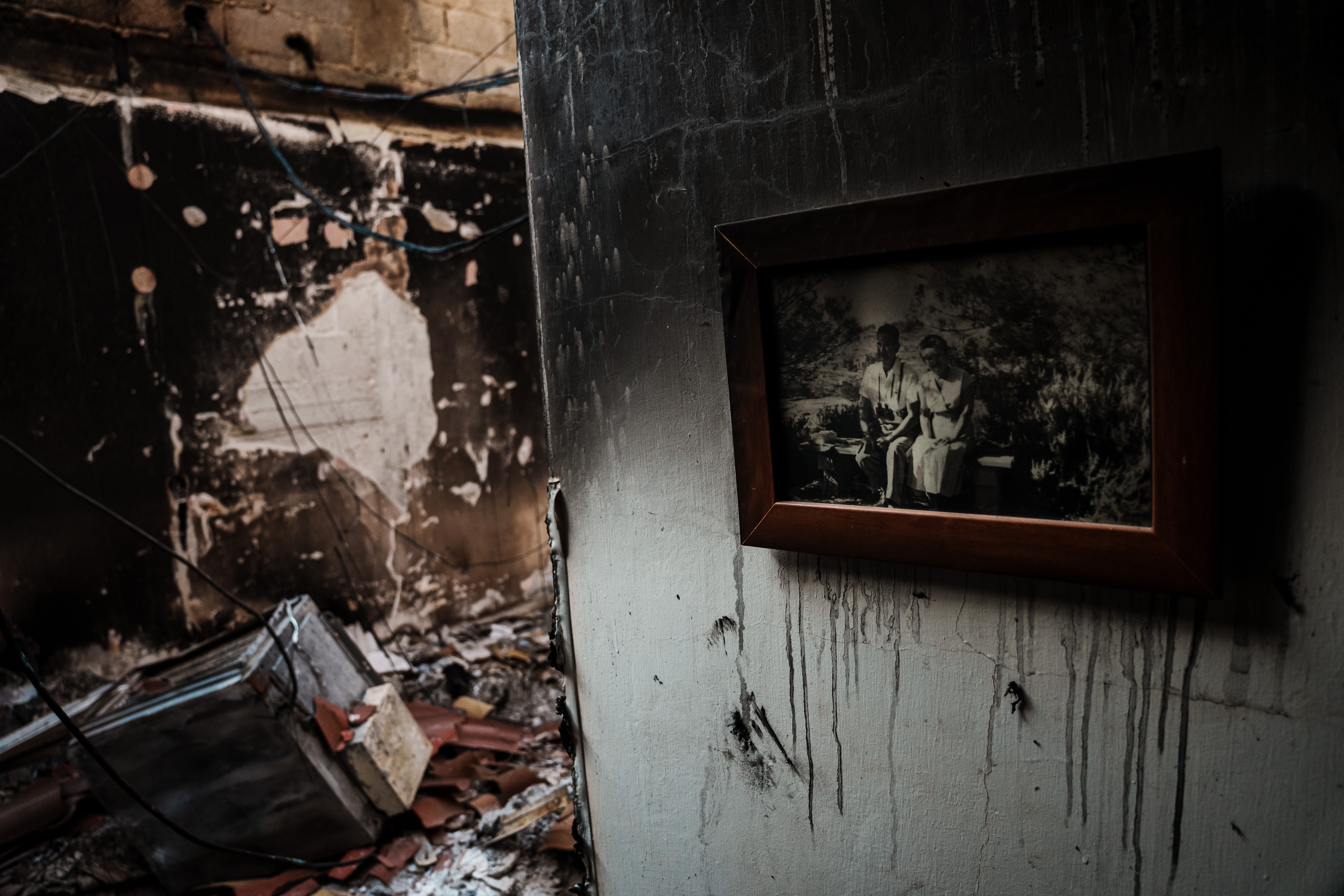 A framed family photo hung up on the wall of a burned home