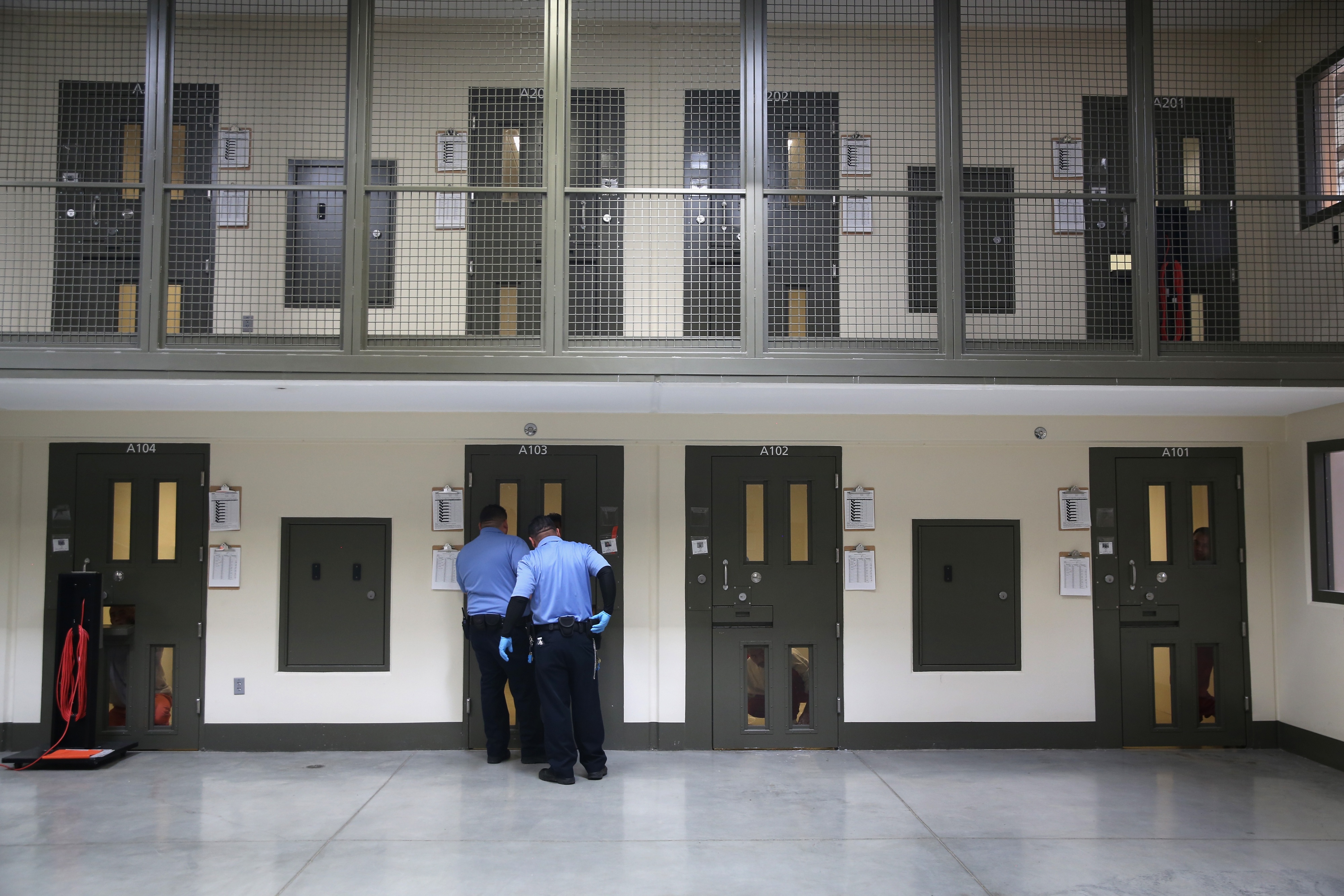 Los guardias se preparan para escoltar a un inmigrante detenido desde su "celda de aislamiento" de vuelta a las instalaciones de la población general en el Centro de Detención de Adelanto, Adelanto, California, el 15 de noviembre de 2013.