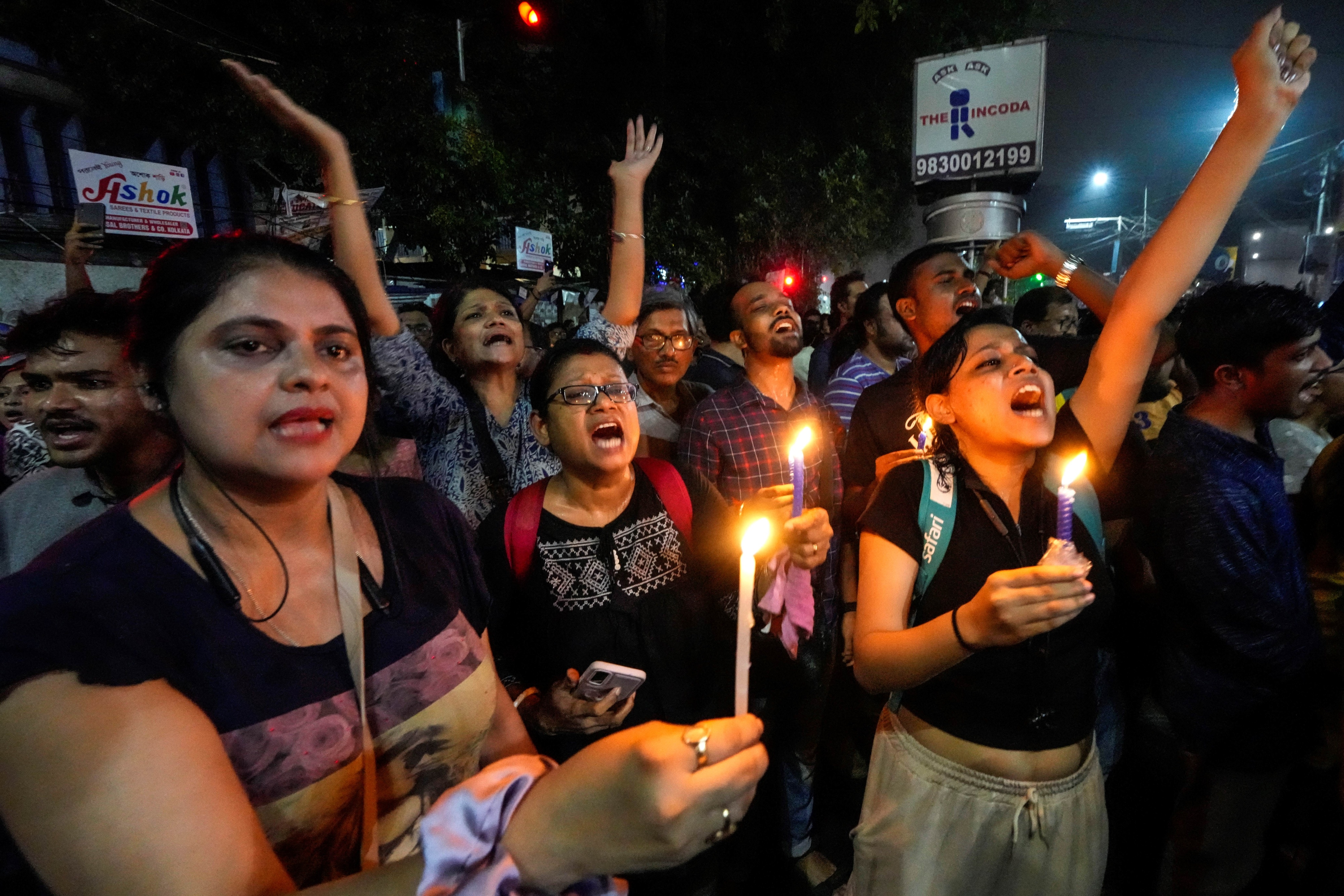 Protesters hold signs and candles 