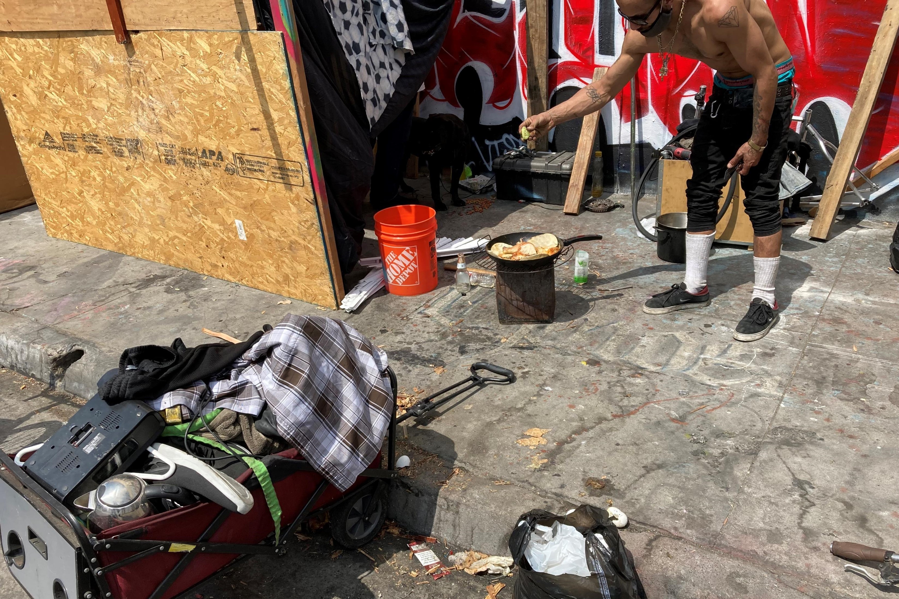 resident of that encampment cooking on a makeshift stove 