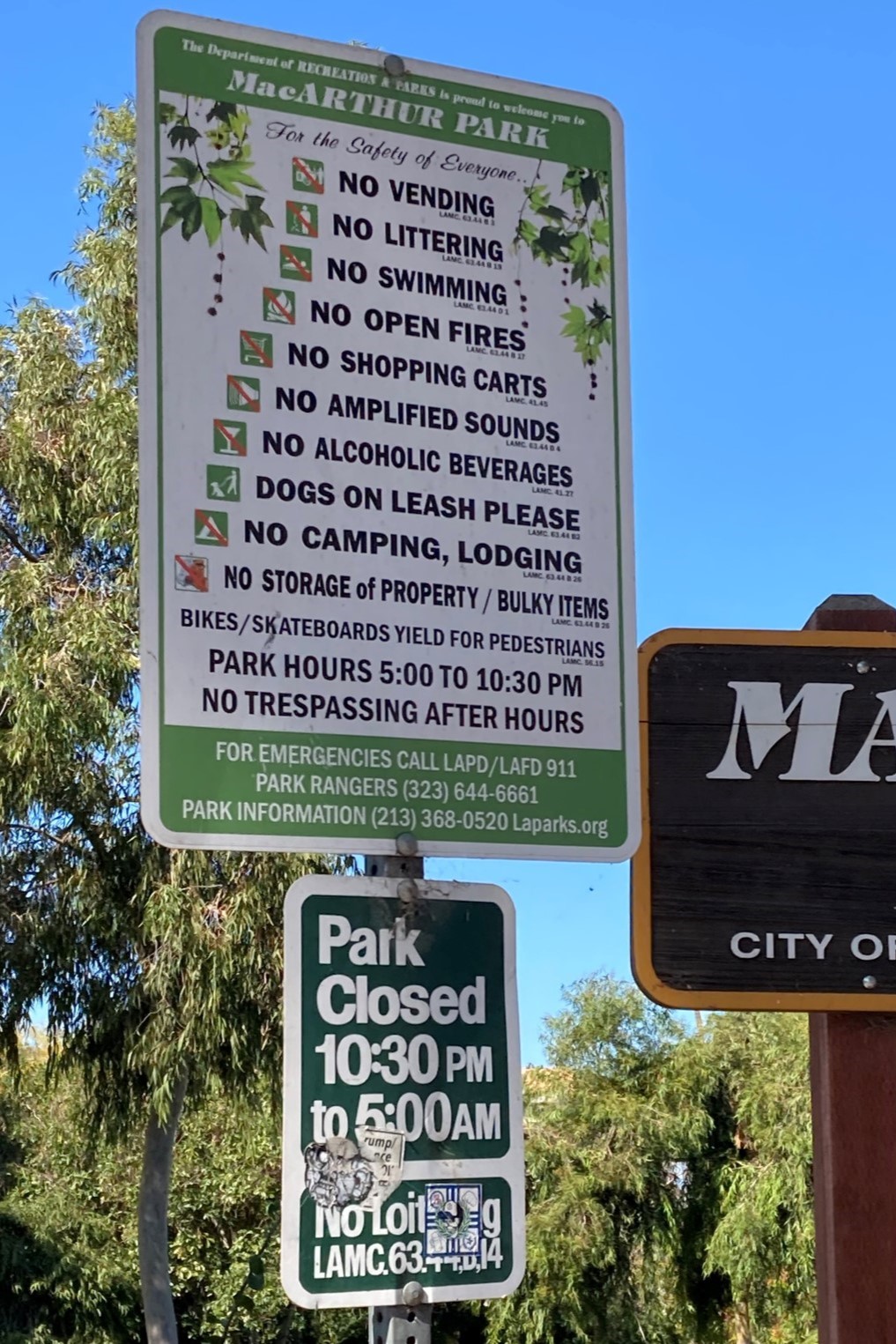 sign at a park entrance notifying the public of rules only enforced against unhoused people