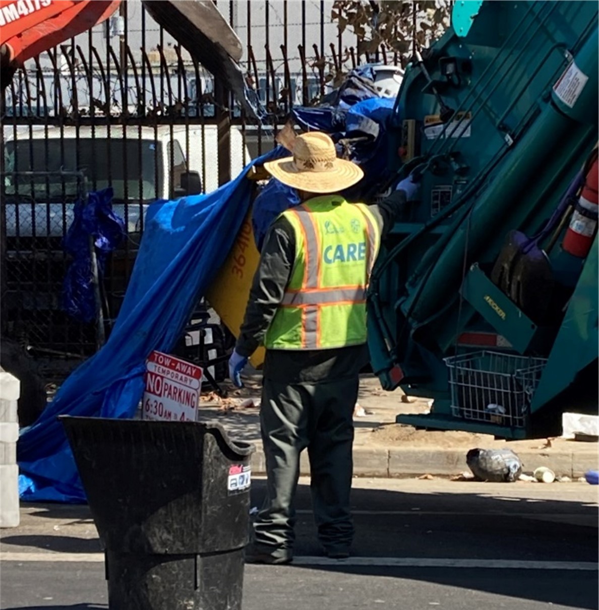 A worker dismantles an encampment during a sweep 