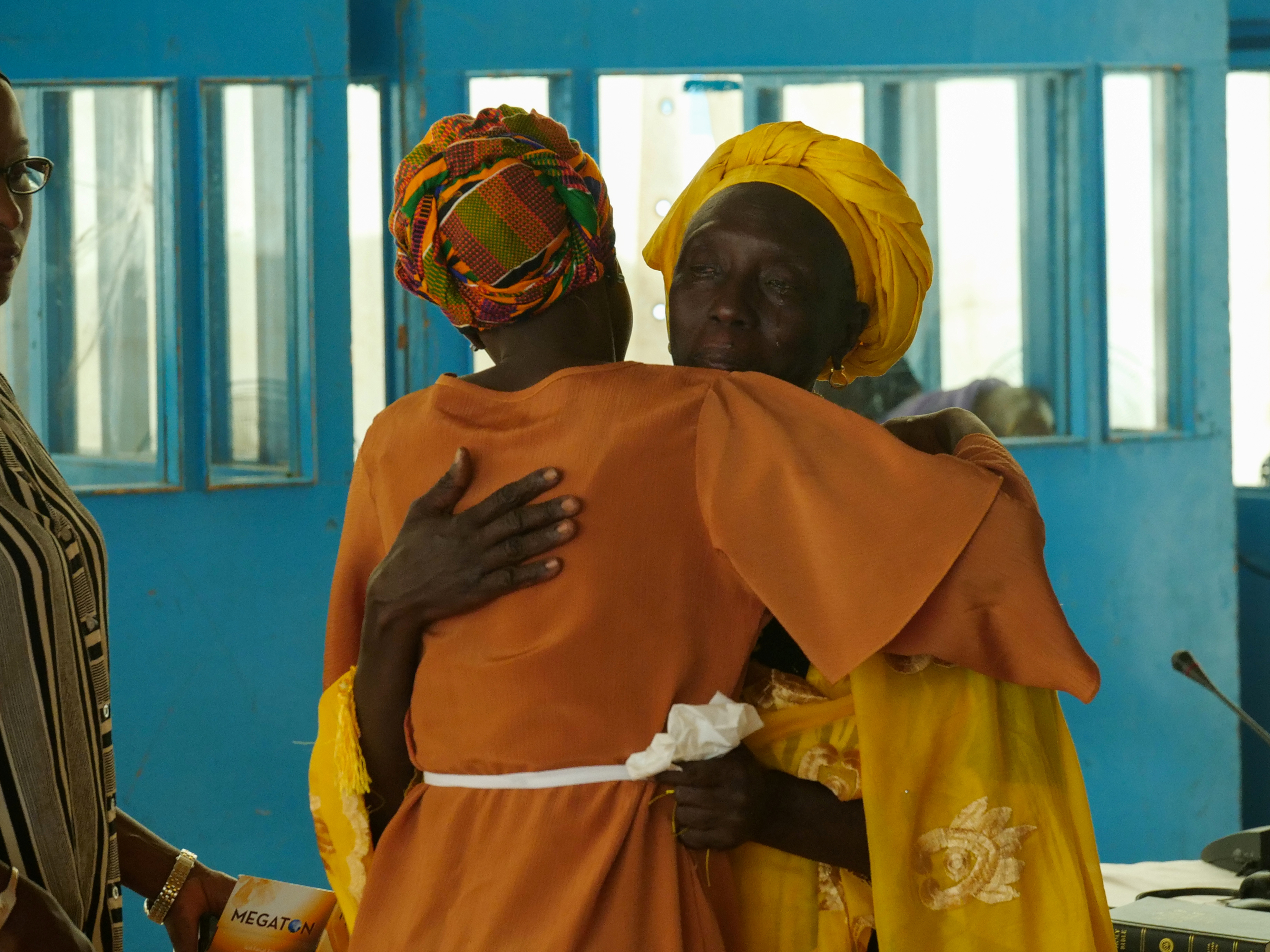 A witness embraces counsel at the Gambian Truth, Reconciliation and Reparations Commission, which called for the prosecution of former President Jammeh, the “Junglers” and others for alleged crimes, in Eassau, Gambia. 