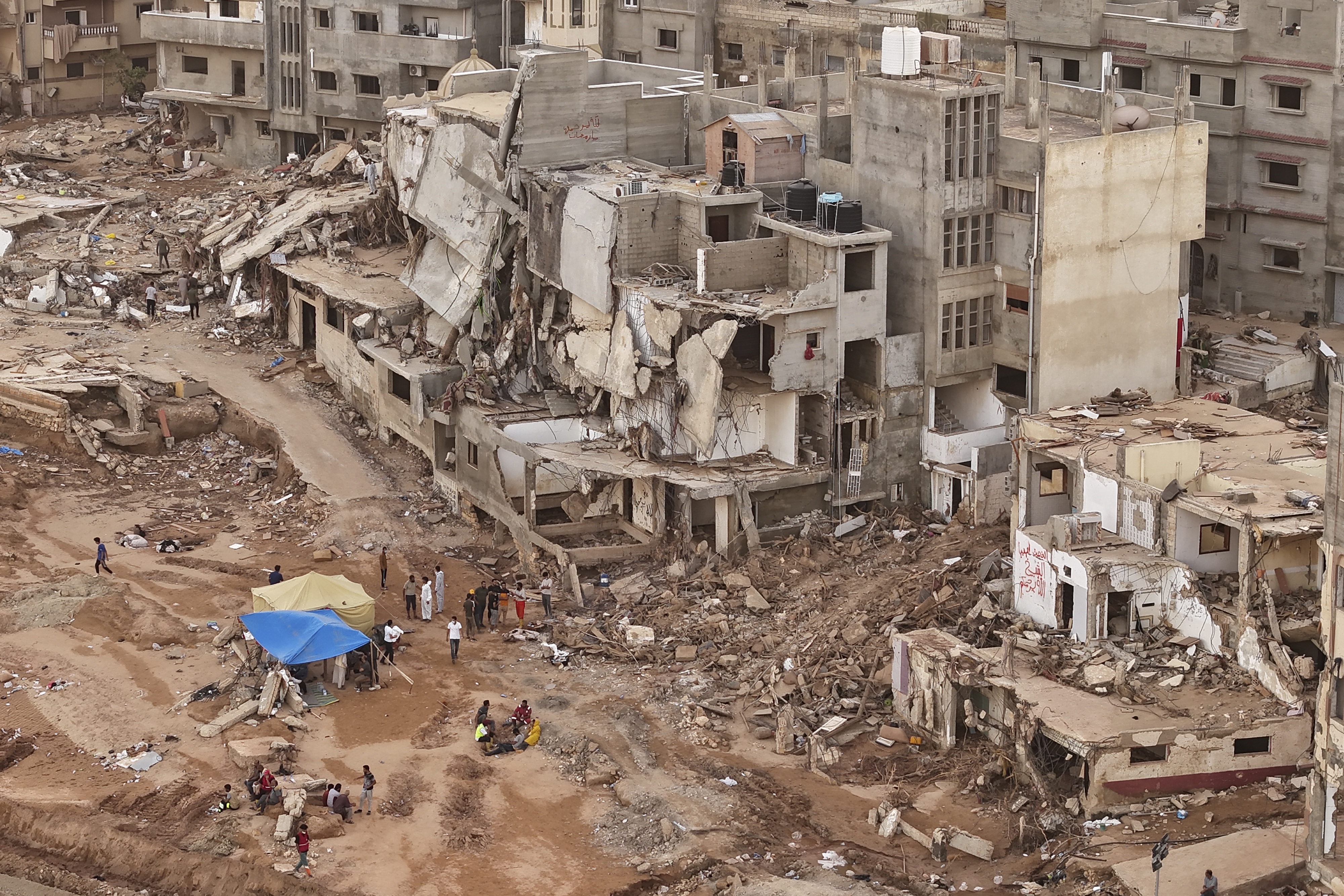 Rescuers and relatives of victims set up tents in front of collapsed buildings in Derna, Libya, September 18, 2023.