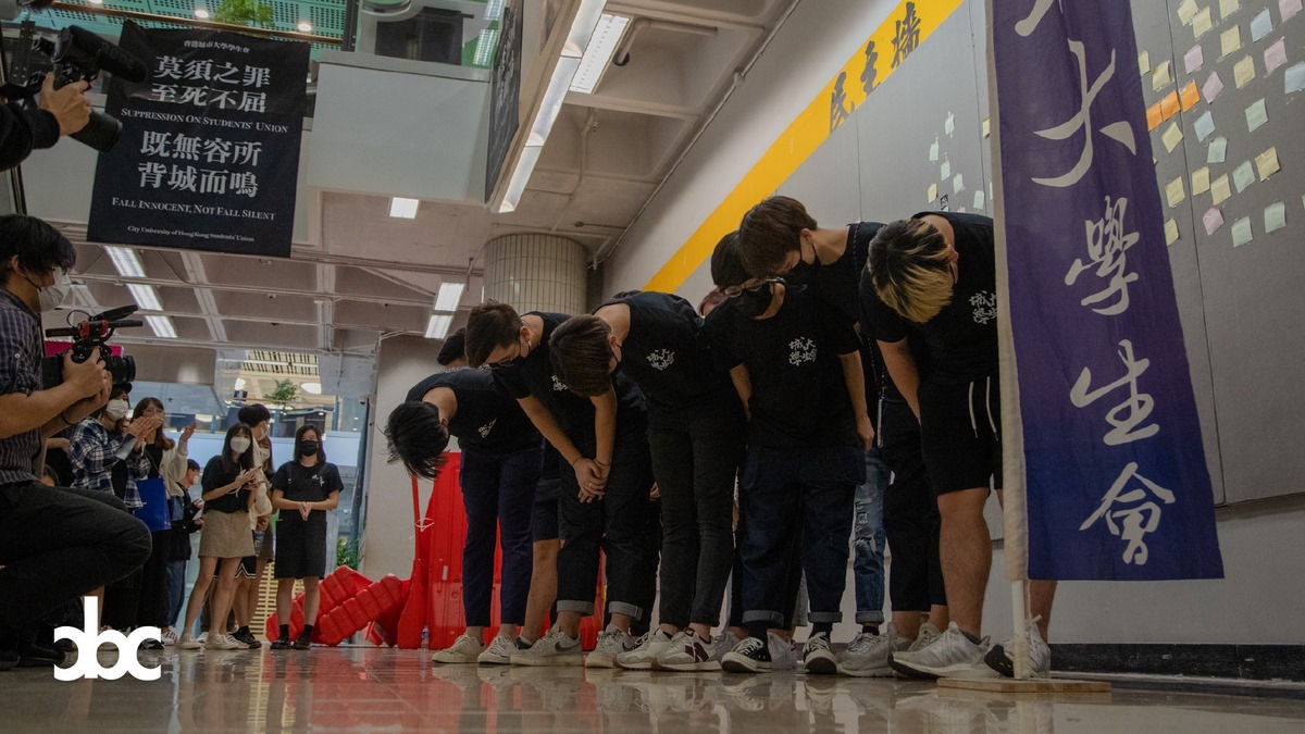 A group of students wearing face masks bowing