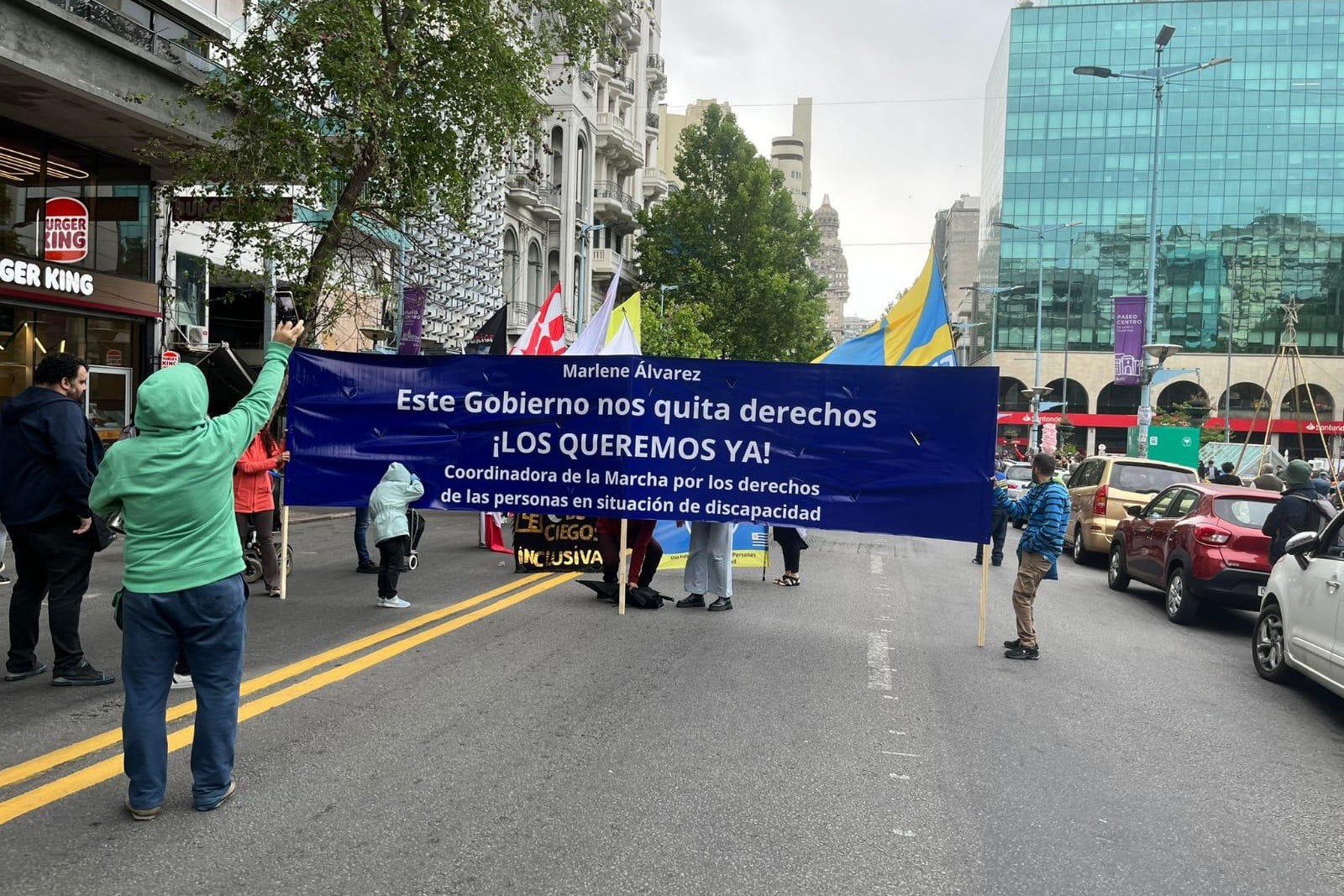 People marching with a banner down a city street