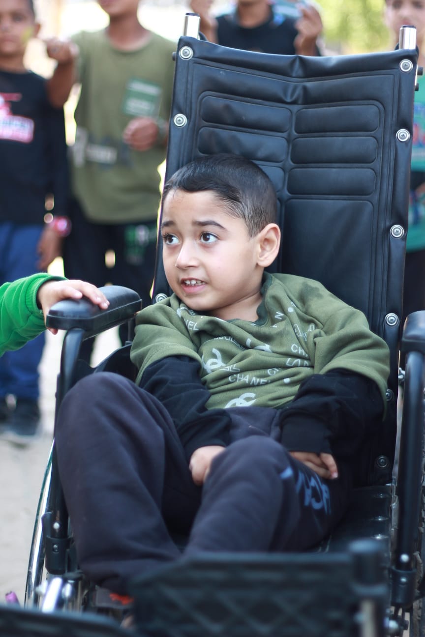 A boy sitting in an adult wheelchair