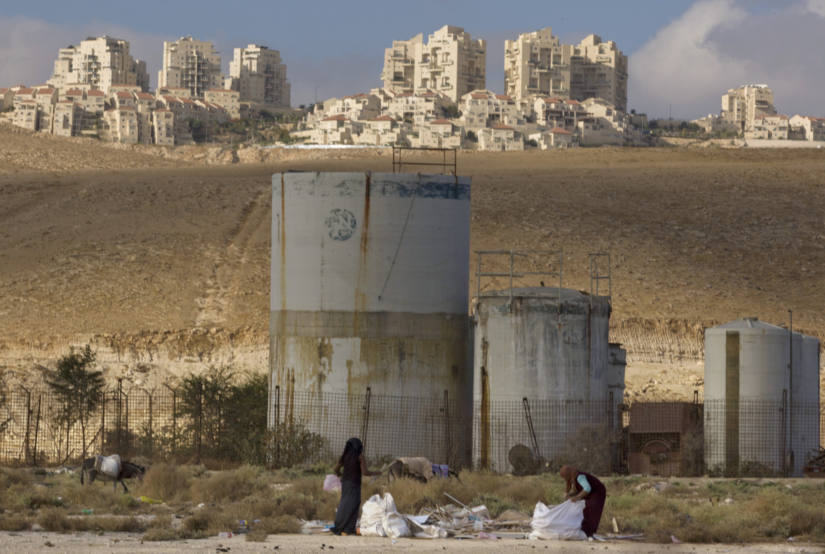 People collect scrap timber in the Mishor Adumim industrial zone near the Israeli settlement of Maaleh Adumim, November 22, 2010.