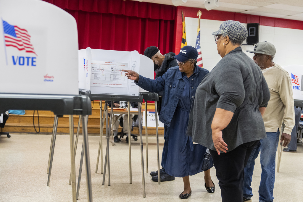 Election workers help voters on the state's primary election day at Lewisdale Elementary School in Chillum, Maryland, May 14, 2024.