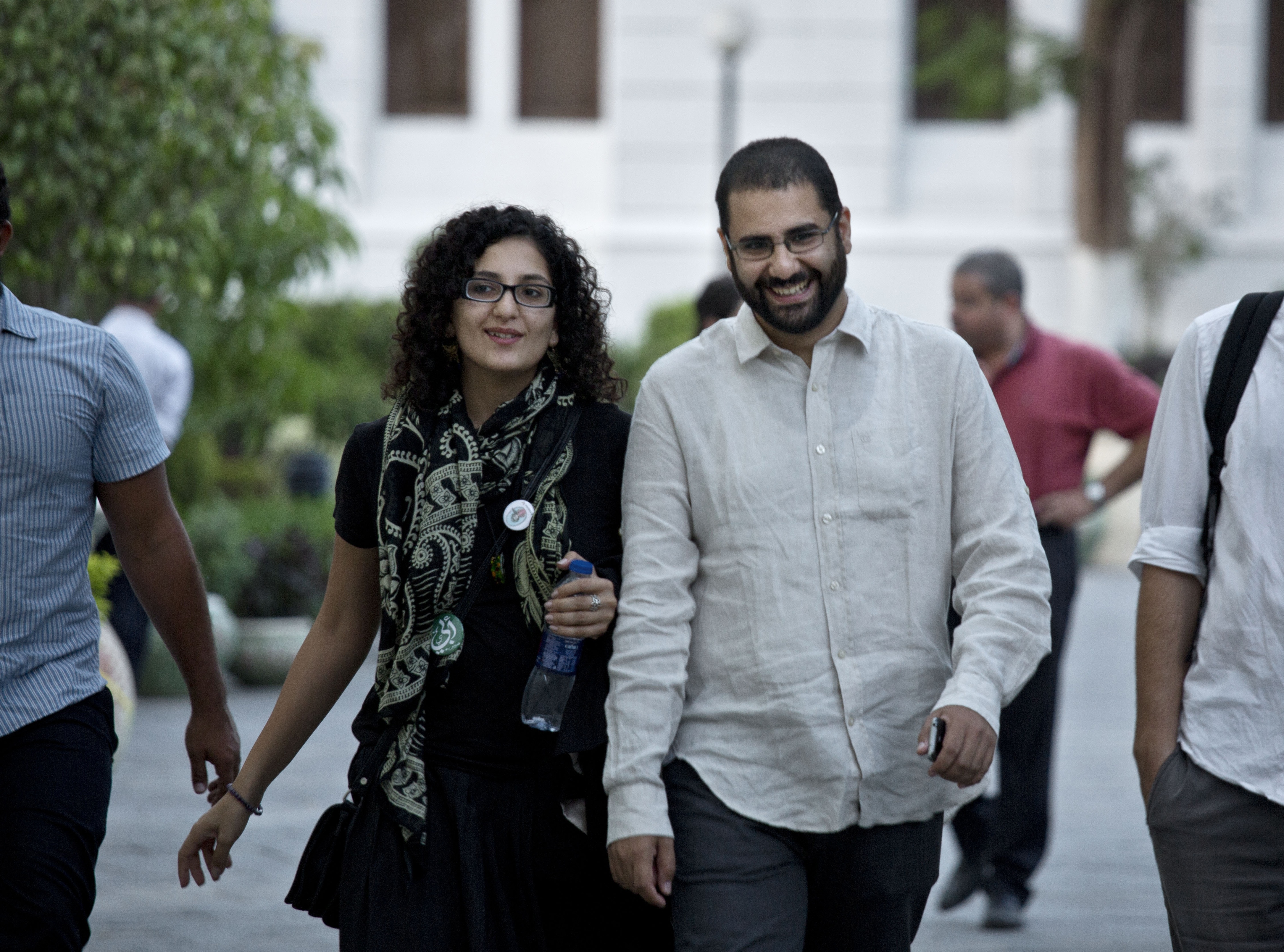 Egyptian activist Alaa Abdel-Fattah (R) walks with his sister Mona Seif prior to a conference held at the American University in Cairo, Egypt, September 22, 2014.