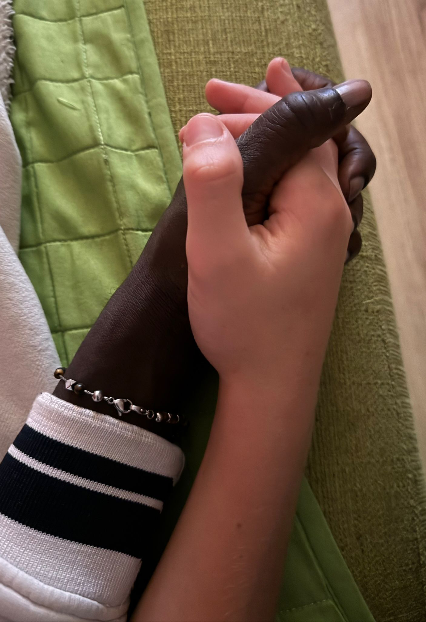 Keita, a 30-year-old from Mali who was rescued by the Italian Coast Guard in 2014, holds hands with the teen-aged son in the Italian family with whom he has grown close.